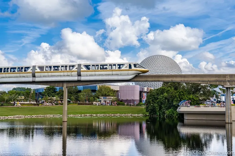 Monorail passing over the water with Spaceship Earth in Epcot