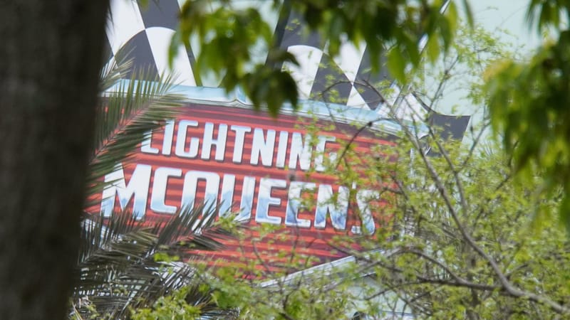 Lightning McQueen's Racing Academy Construction Update March 2019 close up of sign through the trees