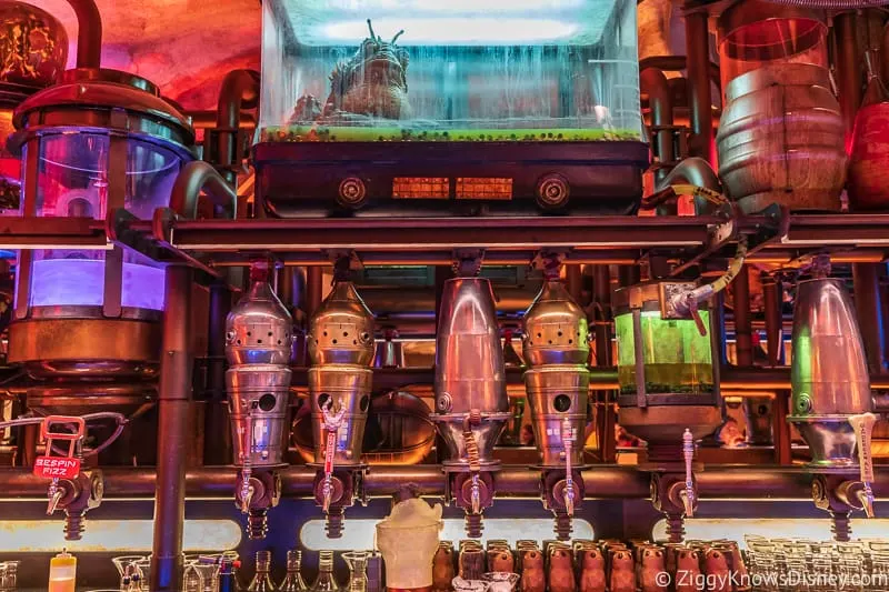 taps behind the bar in Oga's Cantina