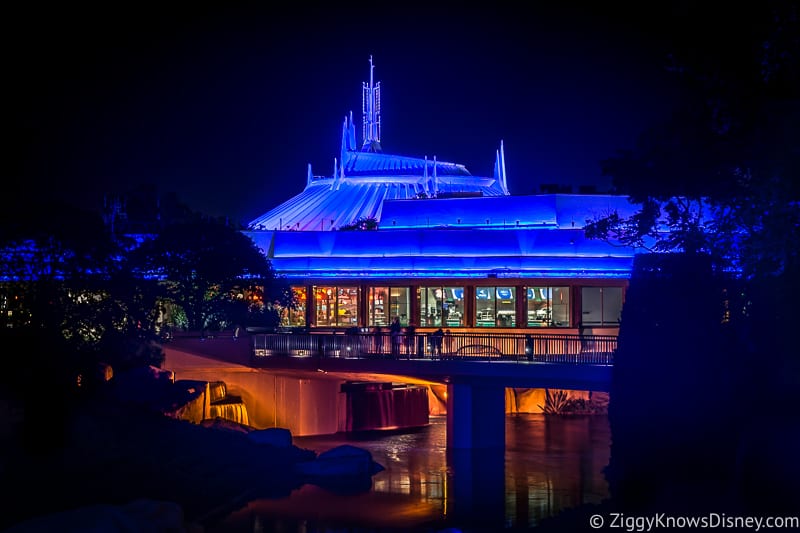 Space Mountain lit up blue at night in the Magic Kingdom