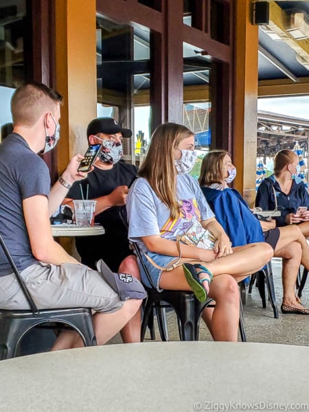 Guests sitting at tables with face masks in Disney World