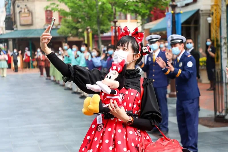 guests wearing mask taking selfie in Disney park
