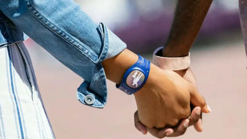 Couple holding hands and wearing MagicBand+