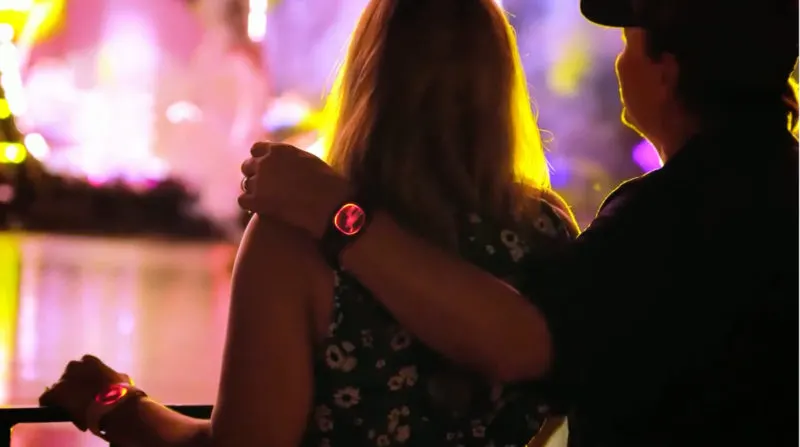 couple wearing MagicBand+ while watching EPCOT fireworks