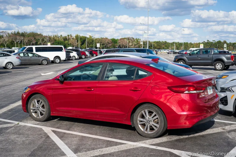 red car in Disney World parking lot