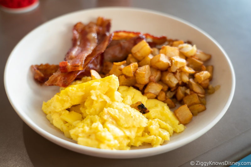 breakfast with scrambled eggs potatoes and bacon at Disney's Art of Animation Resort
