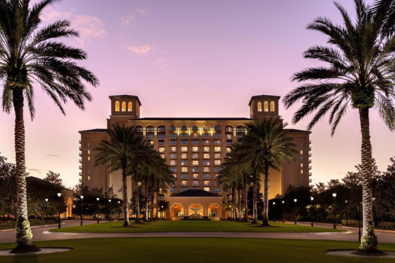 The Ritz-Carlton Orlando Grande Lakes hotel outside with palm trees and sunset