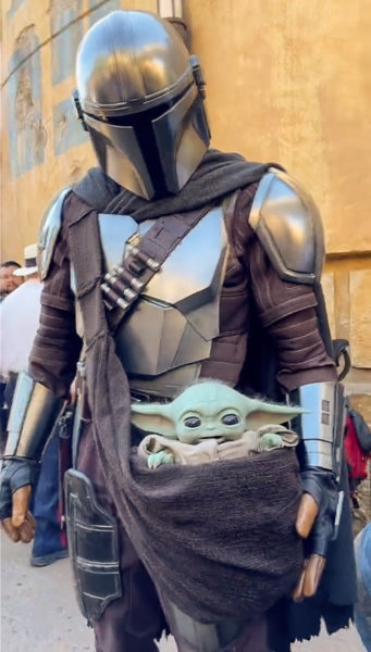 Grogu sitting in a satchel with The Mandalorian