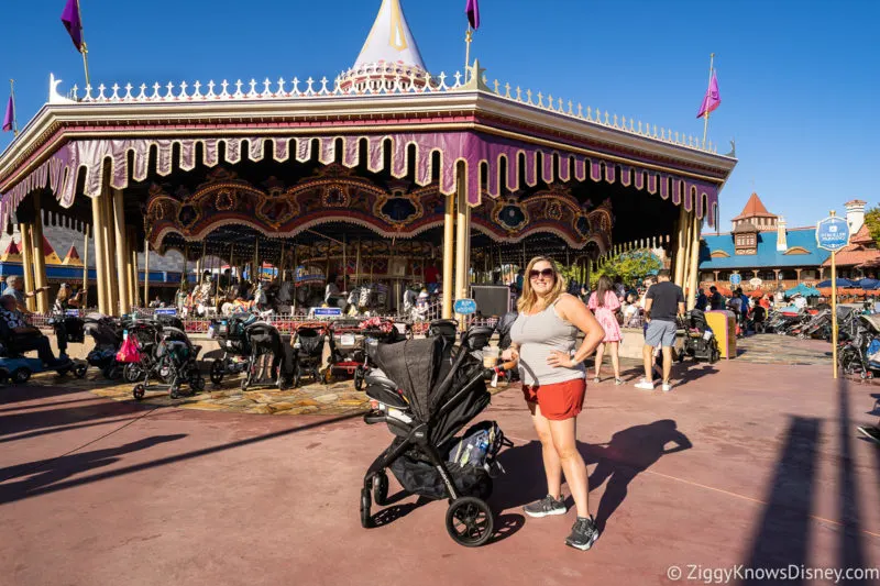walking with a baby stroller in front of Prince Charming Regal Carousel
