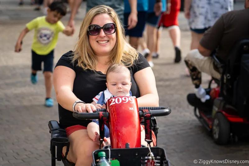Guest riding scooter ECV with baby in Disney World