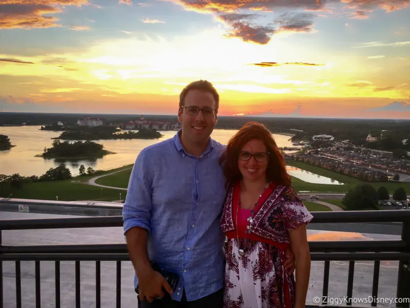 2 guests on top of Contemporary Resort California Grill at sunset over Seven Seas Lagoon