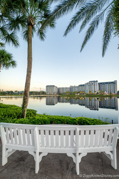 Looking at Disney's Riviera Resort across the lake with white bench in front